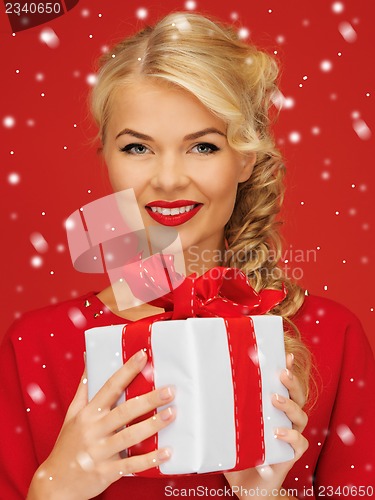 Image of lovely woman in red dress with present