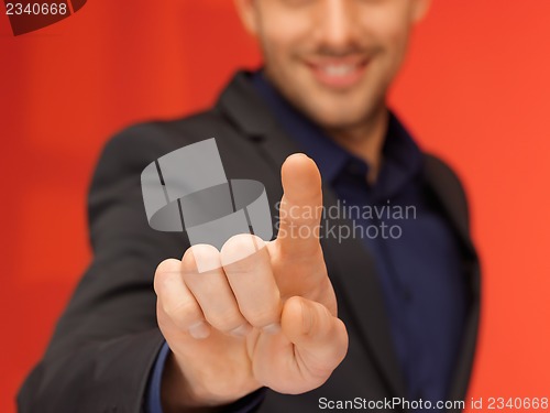 Image of handsome man in suit pressing virtual button