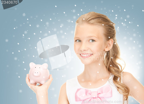Image of lovely teenage girl with piggy bank