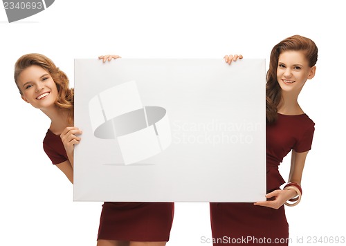 Image of two teenage girls in red dresses with blank board
