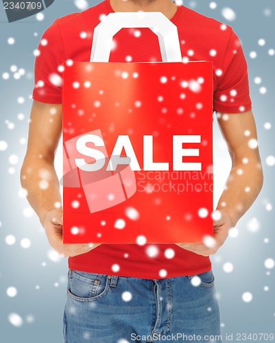 Image of man's hands holding shopping bag