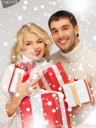 Image of family couple in a sweaters with gift boxes