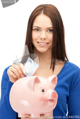 Image of lovely woman with piggy bank and money