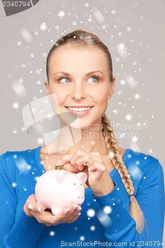 Image of lovely woman with piggy bank and money