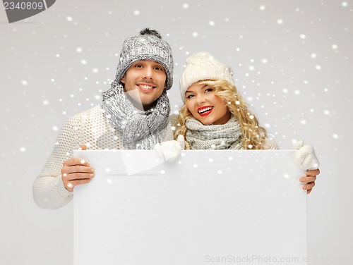 Image of couple in a winter clothes holding blank board