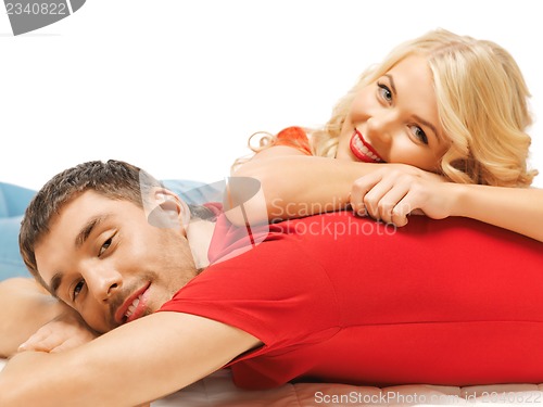 Image of happy couple lying at home
