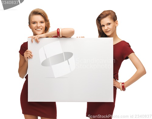 Image of two teenage girls in red dresses with blank board