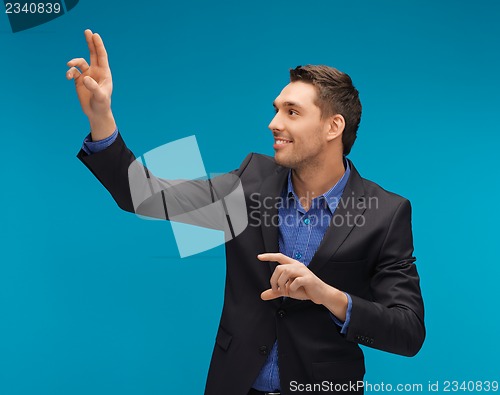 Image of man in suit working with something imaginary