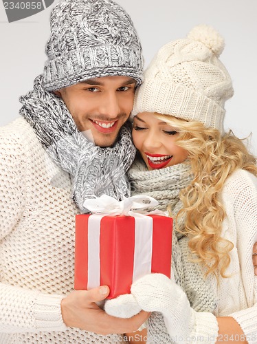 Image of romantic couple in a sweaters with gift box