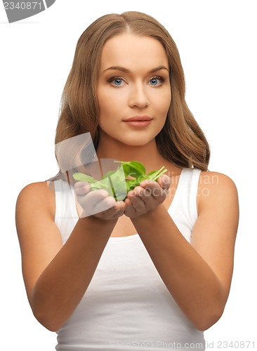 Image of woman with spinach leaves on palms