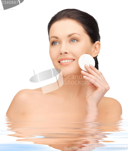 Image of beautiful woman with cotton pad in water