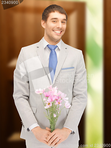 Image of handsome man with flowers in hand