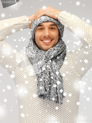 Image of handsome man in warm sweater, hat and scarf