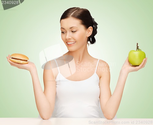 Image of woman with hamburger and apple