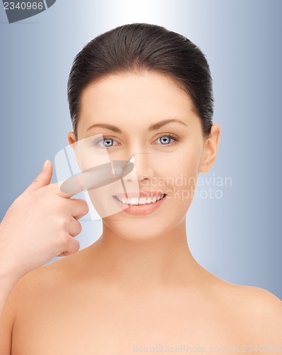 Image of beautiful woman pointing to nose