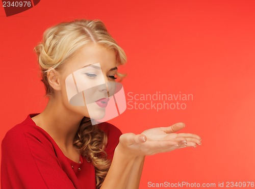 Image of woman blowing something on the palms of her hands