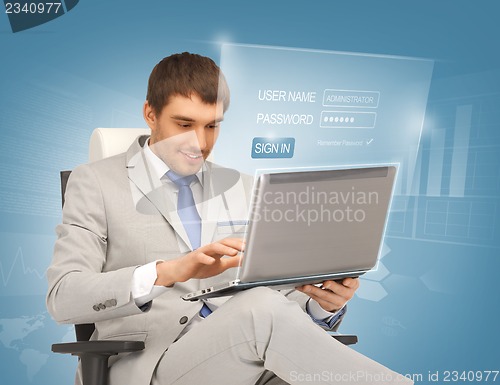 Image of young businessman sitting in chair with laptop