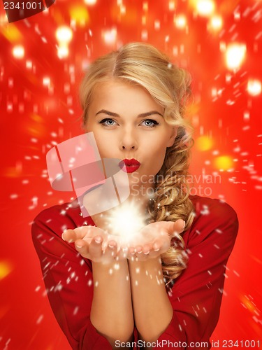 Image of woman blowing something on the palms of her hands