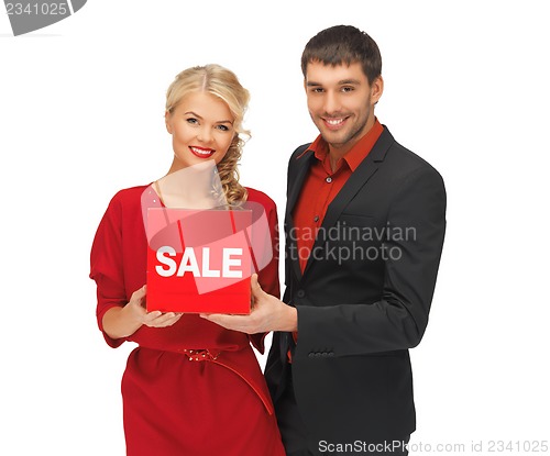 Image of man and woman with sale sign