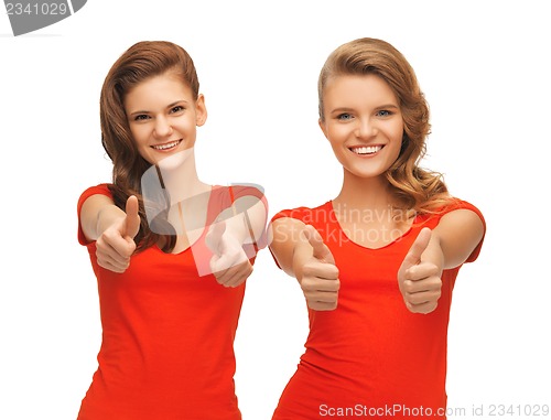 Image of wo teenage girls in red t-shirts showing thumbs up