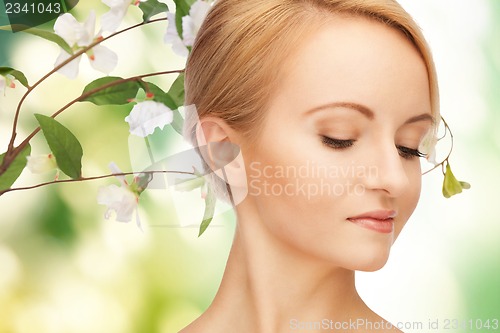 Image of beautiful woman with flowers on twig