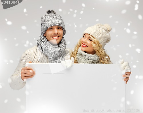 Image of couple in a winter clothes holding blank board