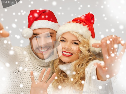 Image of family couple in sweaters and santa's hats