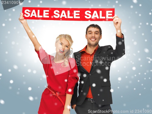 Image of man and woman with sale sign