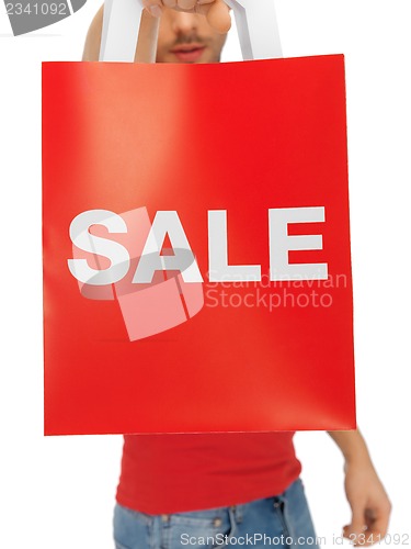 Image of man's hands holding shopping bag