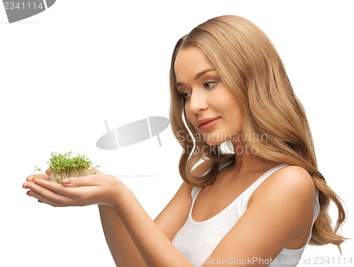 Image of woman with green grass on palms