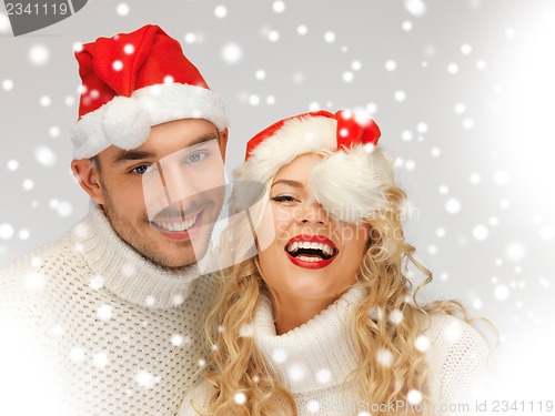Image of family couple in sweaters and santa's hats