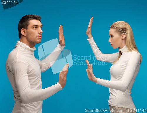 Image of man and woman working with something imaginary