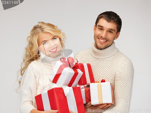 Image of family couple in a sweaters with gift boxes