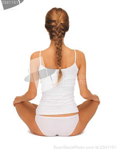 Image of woman in undrewear practicing yoga lotus pose