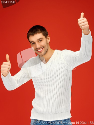 Image of man in warm sweater showing thumbs up
