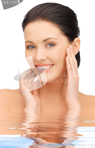 Image of face and hands of beautiful woman in water