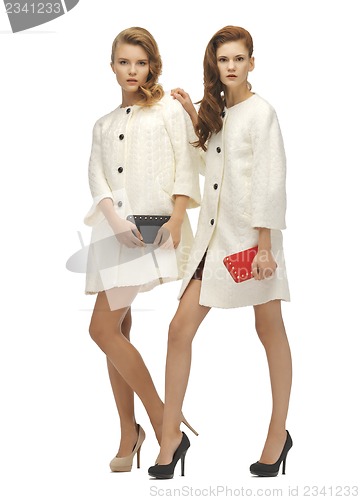 Image of two teenage girls in white coats with clutches