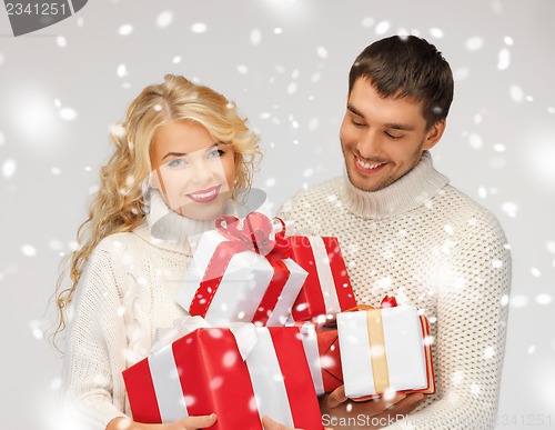 Image of family couple in a sweaters with gift boxes