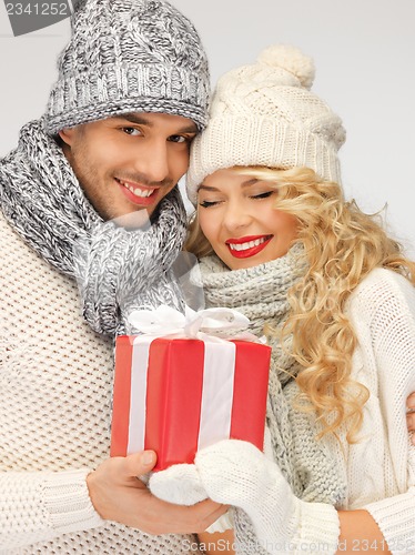 Image of romantic couple in a sweaters with gift box
