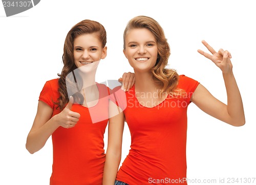 Image of teenage girls showing thumbs up and victory sign