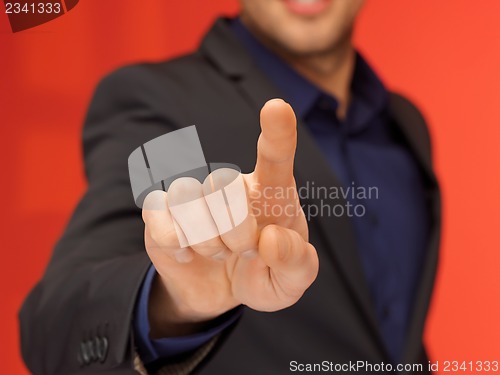 Image of handsome man in suit pressing virtual button