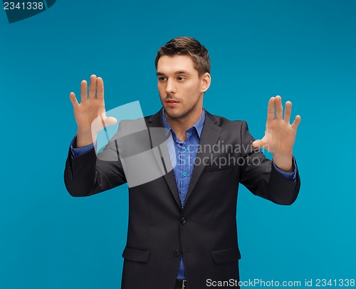 Image of man in suit working with something imaginary