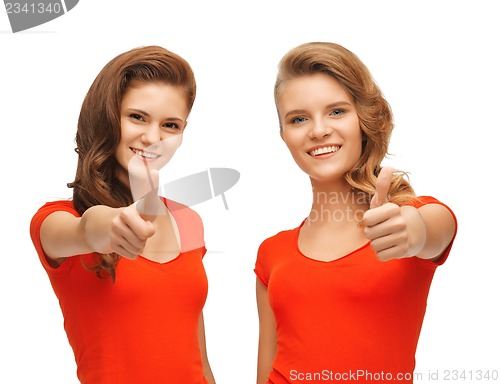 Image of wo teenage girls in red t-shirts showing thumbs up