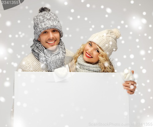 Image of couple in a winter clothes holding blank board