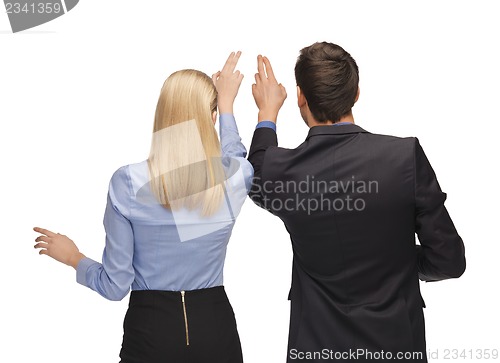 Image of man and woman working with something imaginary