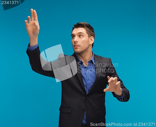Image of man in suit working with something imaginary