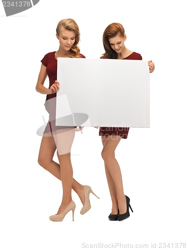 Image of two teenage girls in red dresses with blank board