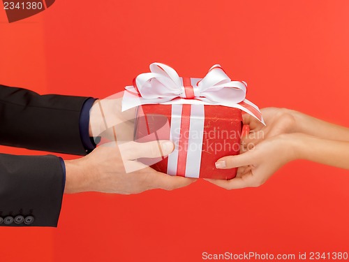 Image of man and woman's hands with gift box