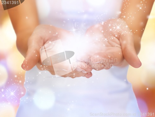 Image of magic twinkles on female hands