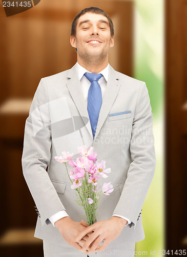 Image of handsome man with flowers in hand